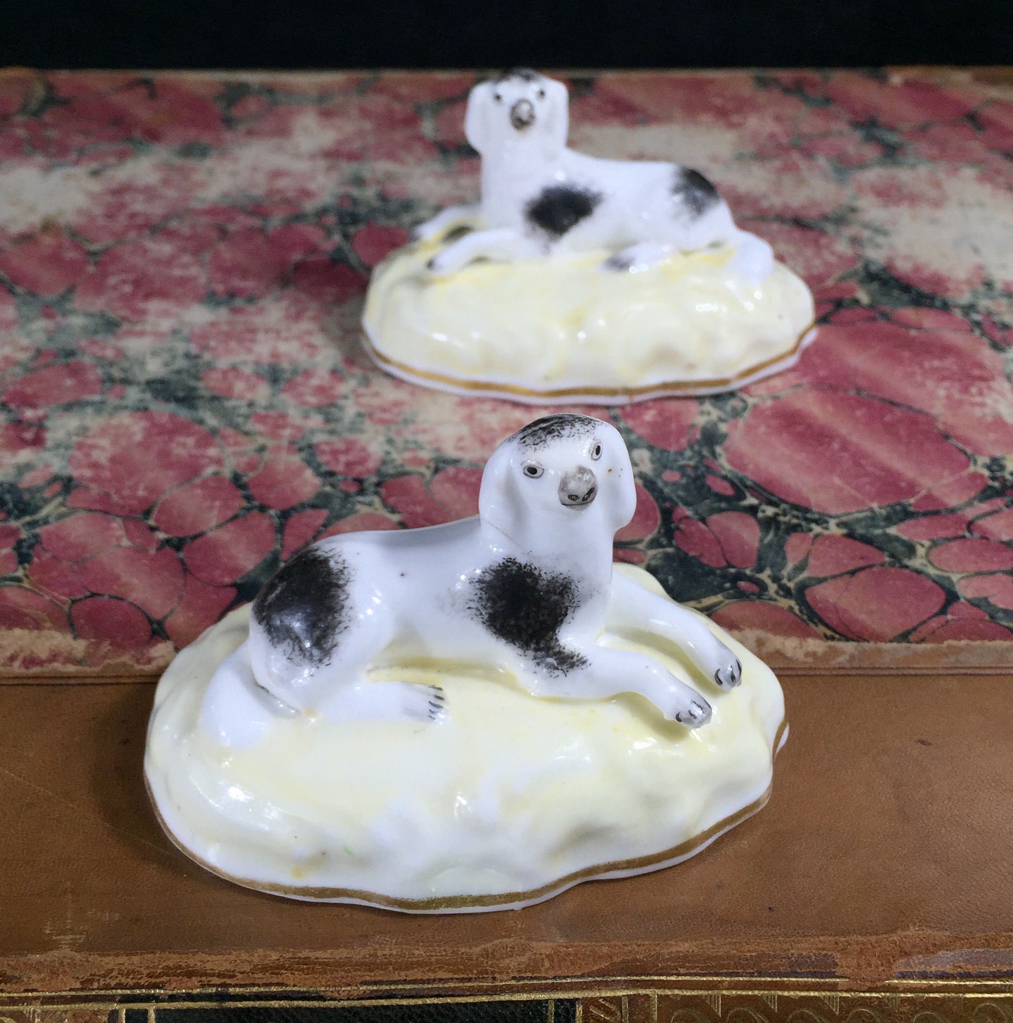 Pair of porcelain reclining spaniels on lemon bases, c. 1835-0