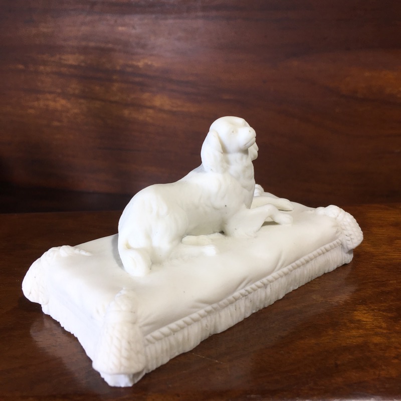 Minton bisque spaniel, lying on a tasselled cushion, Unmarked, circa 1835.-0