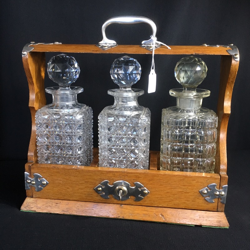 Oak three decanter tantalus, plated mounts, c.1885-0