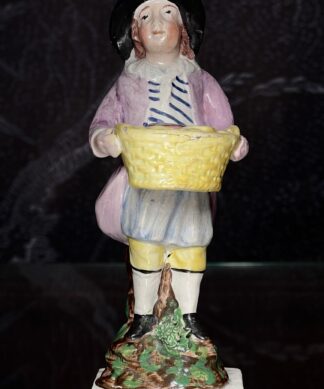 Early Staffordshire figure of a pastry seller, c. 1800