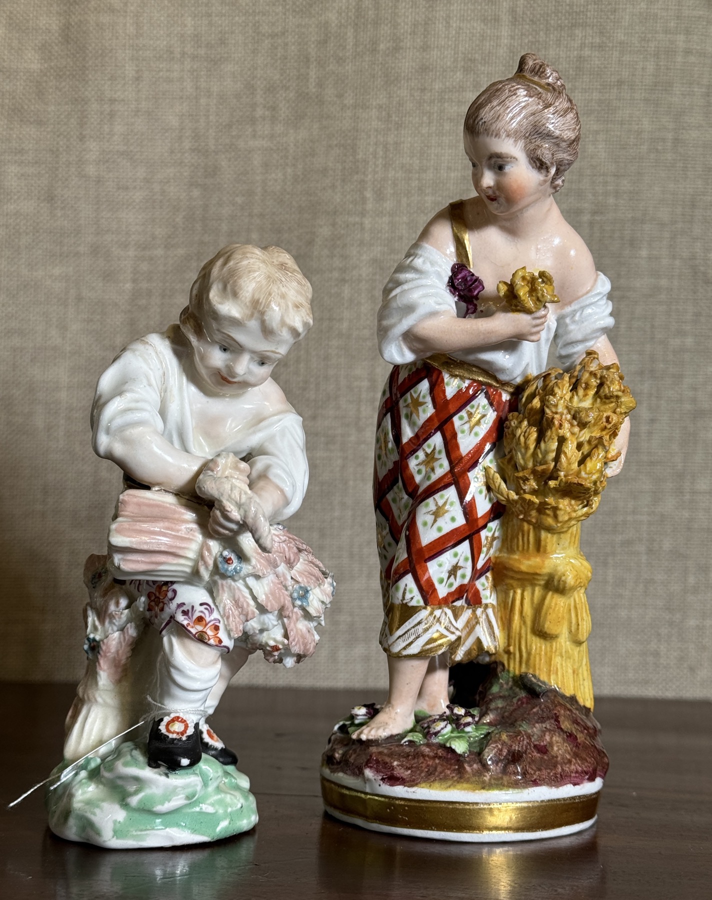 Two Derby figures of 'Summer', showing a child with a sheaf of wheat: left is a boy from the 'Rustic Seasons', c. 1780; right is a girl from the 'French Seasons', c. 1810.  She seems to be criticising his sheaf-binding technique!