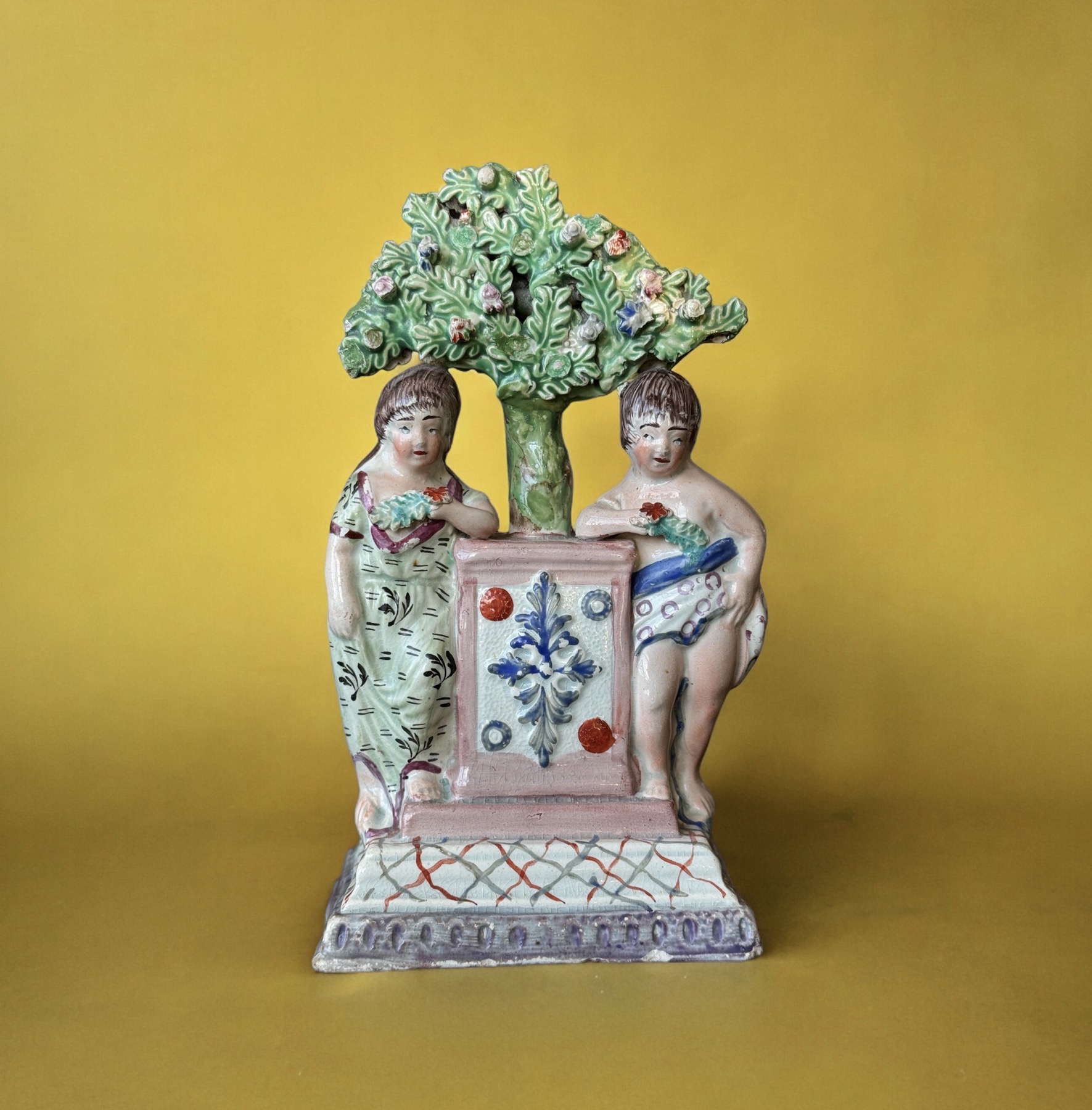 Early Staffordshire group of children with flowers by a large plinth, c. 1810