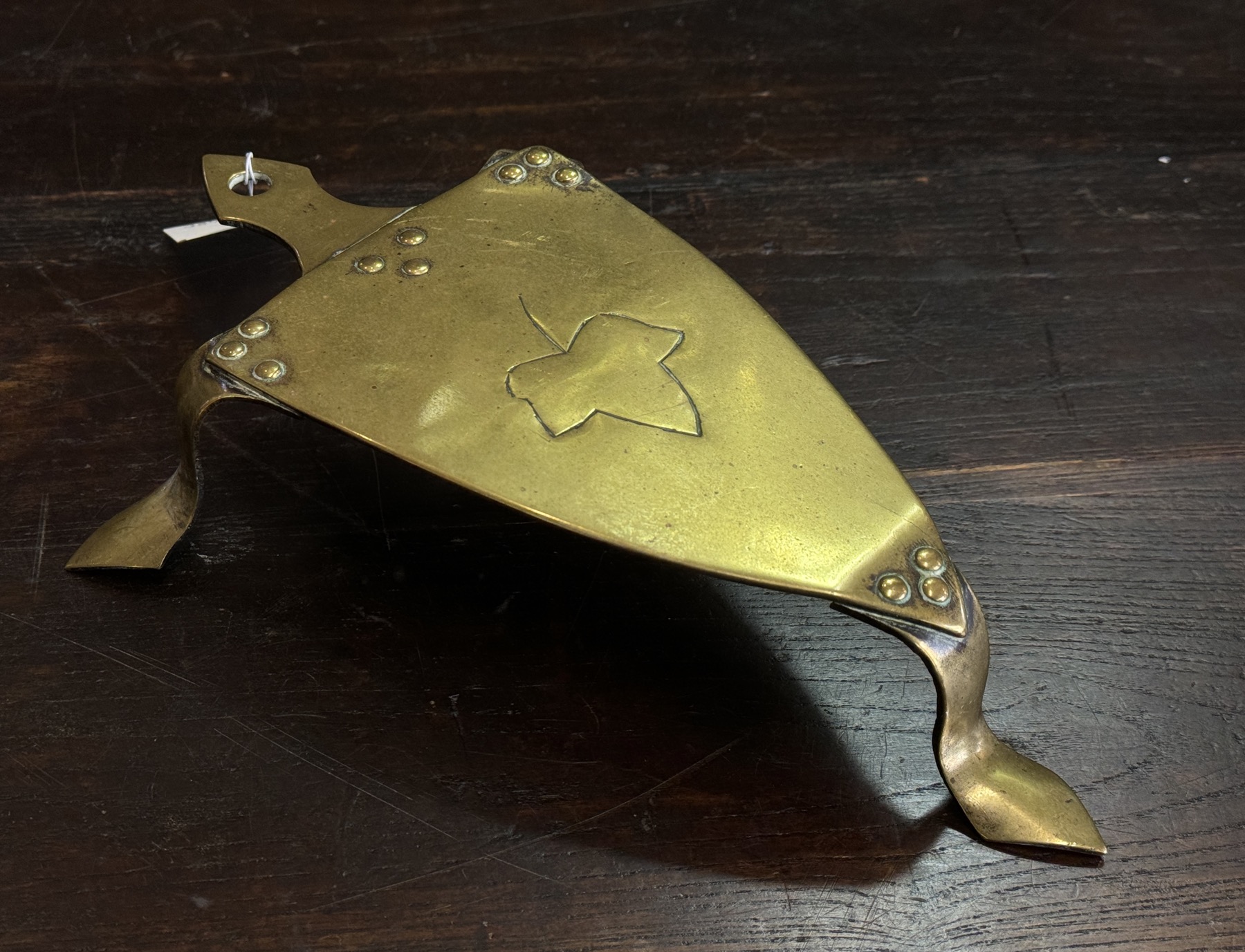 Arts and crafts brass trivet, sheild shape with incised ivy leaf, C . 1905