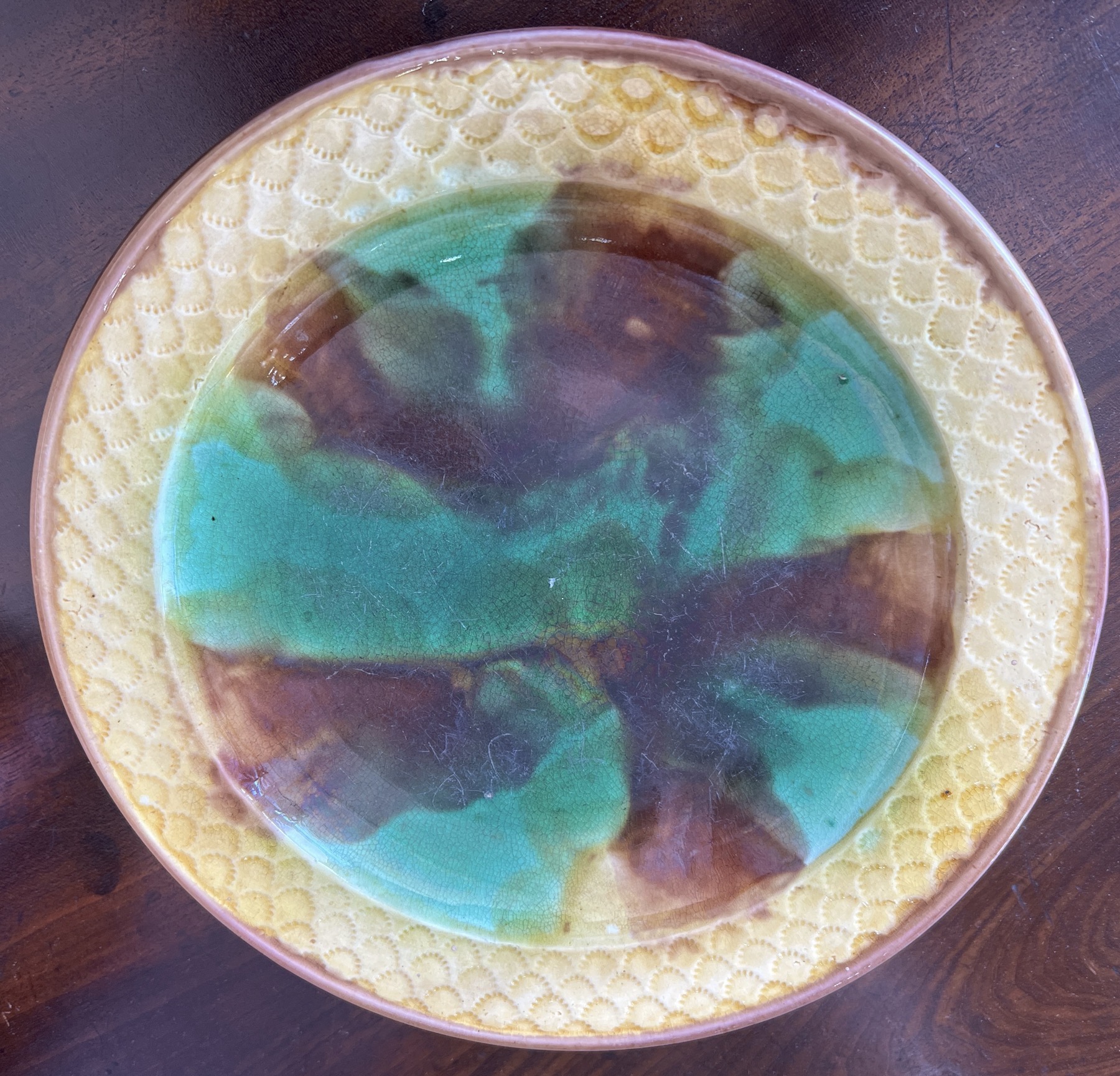 Majolica plate with basketweave rim, green/brown glaze, c. 1880